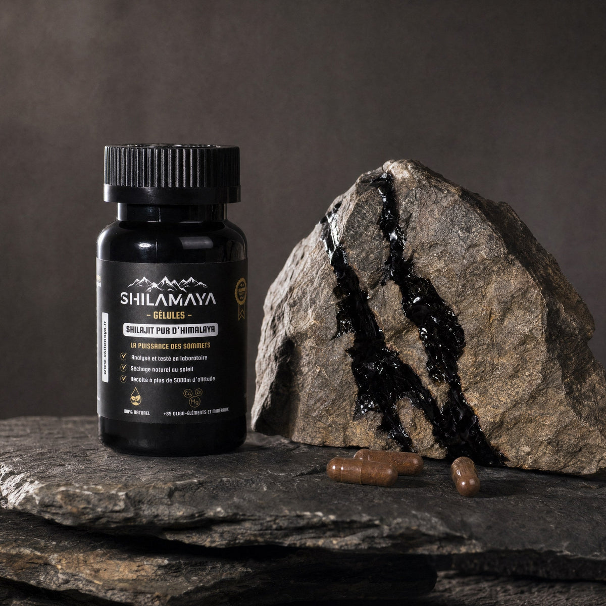 Pot de gélules de Shilajit posé sur la roche brute de l'Himalaya