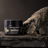 Pot de résine de Shilajit posé sur la roche brute de l'Himalaya