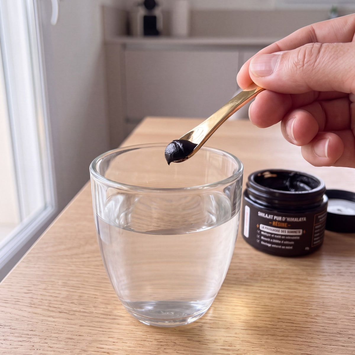Une dose de résine de Shilajit prélevée à la cuillère et diluée dans un verre d'eau tiède